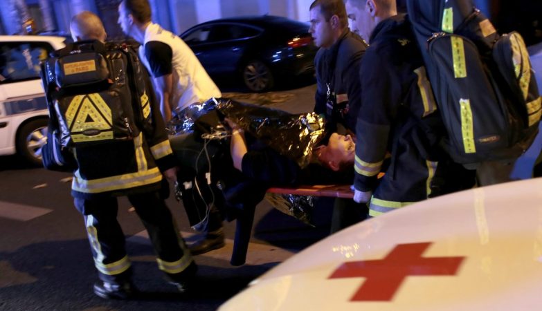 Paramédicos transportam uma mulher ferida após os atentados em Paris