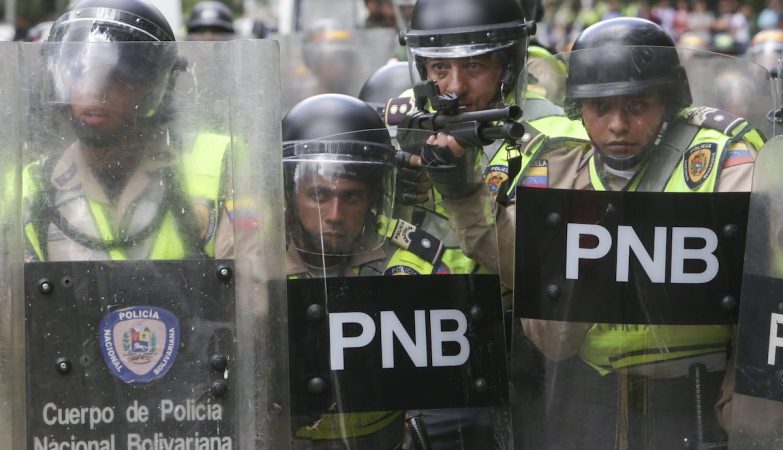 Agentes da Polícia Nacional Bolivariana em formação contra opositores em protestos pelo referendo na Venezuela