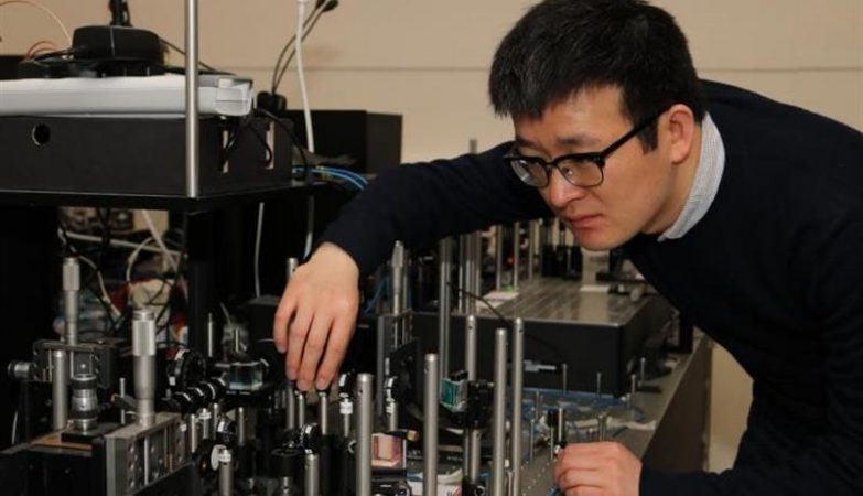 Xiaogang Qiang, da Universidade de Bristol, com um computador quântico primitivo