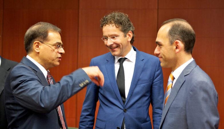 Guikas Hardouvelis, ministro das Finanças da Grécia (esq.) com Jeroen Dijsselbloem, presidente do Eurogroup, e Charis Georgiades, ministro das Finanças do Chipre