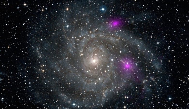 Em 2012 o Nustar registou os raios-X de alta energia emitidos por dois buracos negros (mostrados em magenta) perto da distante galáxia espiral IC 342