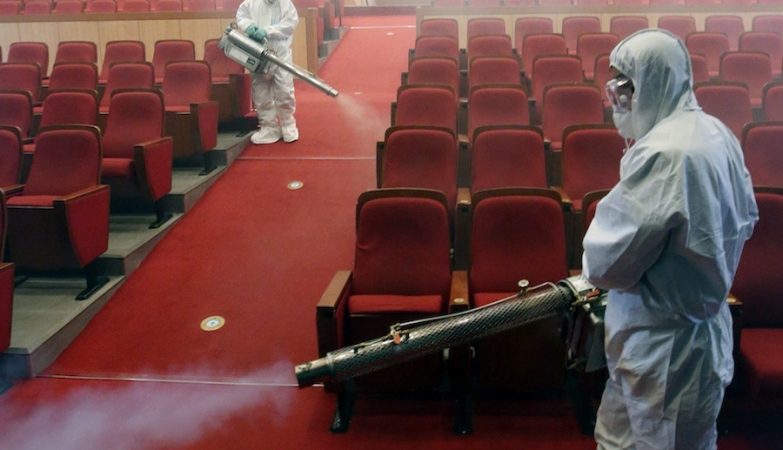 Dois técnicos de saúde desinfectam um teatro em Seul como precaução contra o coronaviírus MERS