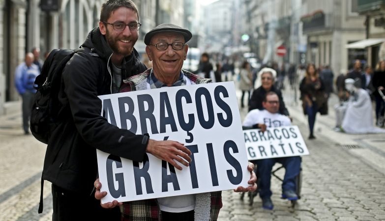 Um idoso do Centro Comunitário da Gafanha do Carmo distribui abraços na rua de Santa Catarina, no Porto, numa campanha de sensibilização contra o abandono sénior nos lares