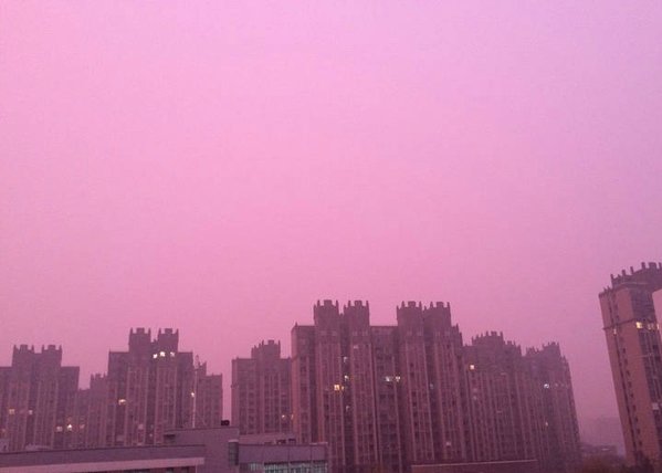 O céu de Nanjing, China, cor-de-rosa com a poluição