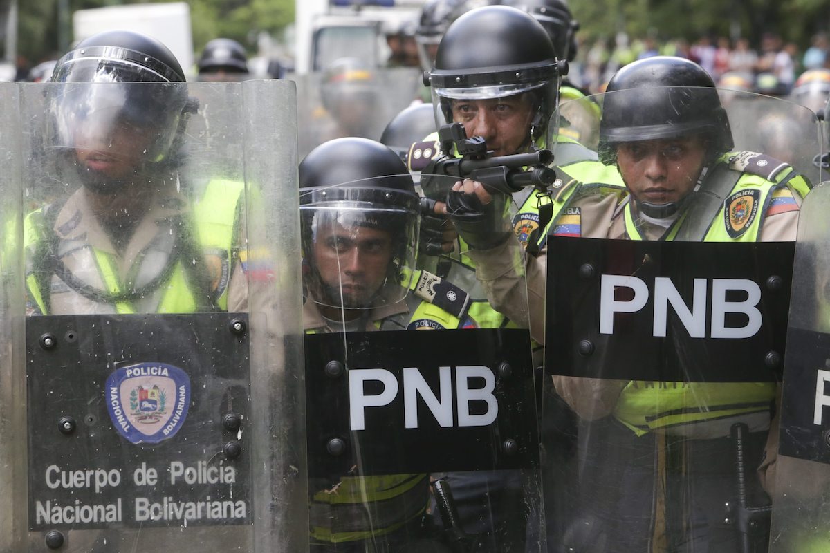 Agentes da Polícia Nacional Bolivariana em formação contra opositores em protestos pelo referendo na Venezuela