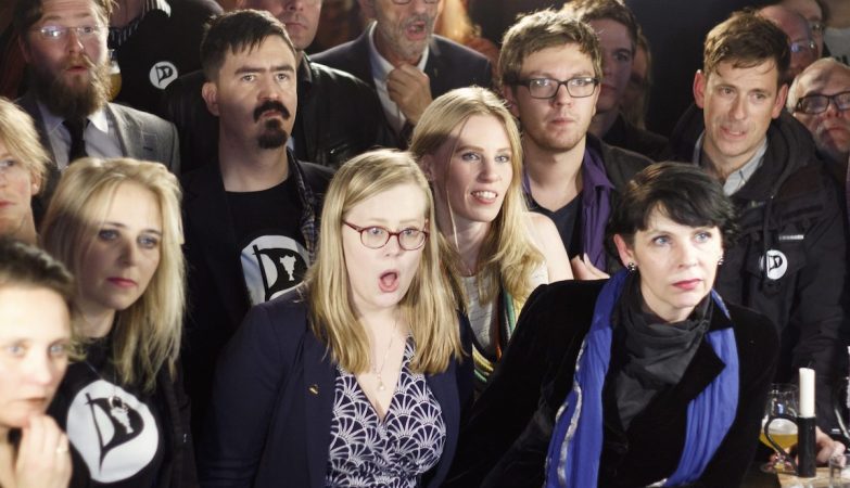 Birgitta Jónsdóttir, líder do Partido Pirata da Islândia (dir), e militantes do partido reagem aos resultados das eleições