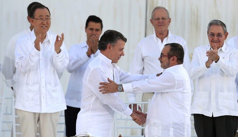 O presidente da Colômbia, Juan Manuel Santos, e o líder das FARC, Rodrigo "Timochenko" Londono Echeverri, apertam as mãos depois da assinarem um histórico acordo de paz.