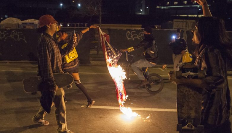 Manifestantes queimam a bandeira dos EUA na segunda noite de protestos contra a eleição de Donald Trump