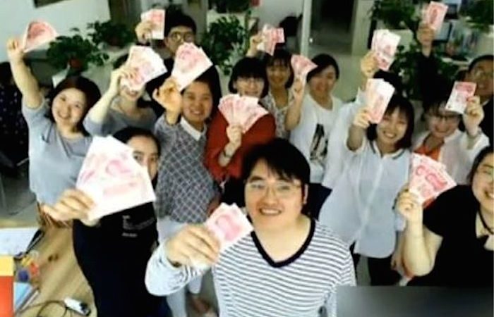 Funcionários da Xian Jingtian Investment Consulting mostram os yuans que ganharam com os quilos que perderam