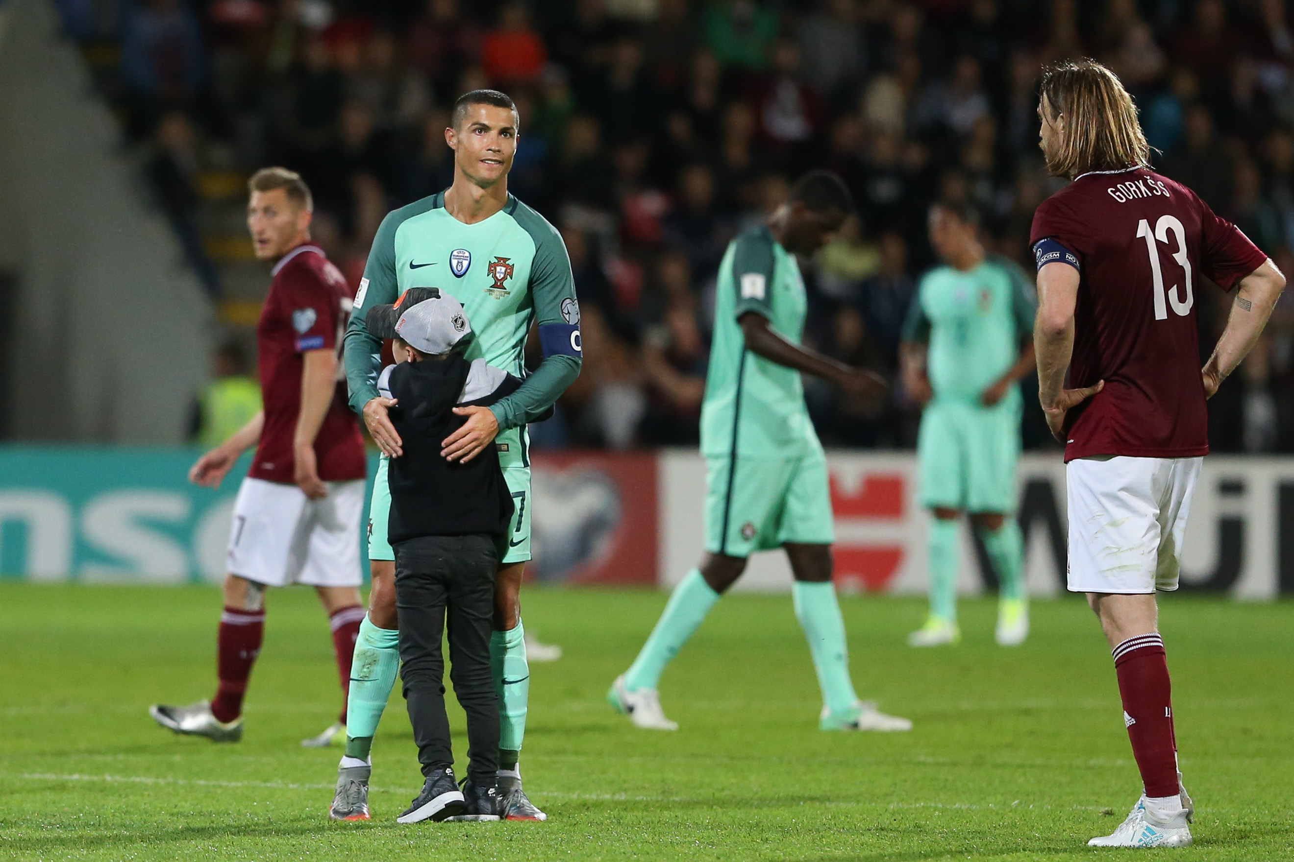 Uma criança foge aos seguranças e abraça Cristiano Ronaldo no fim do jogo com a Letónia