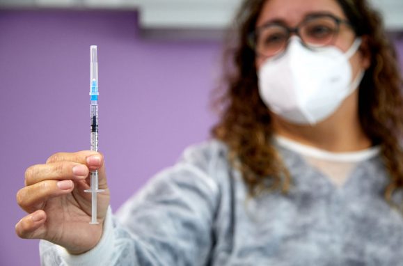 Enfermeira com uma vacina na mão