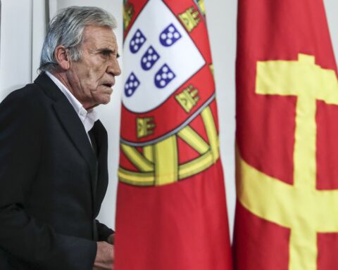 O secretário-geral do PCP, Jerónimo de Sousa, com a bandeira de Portugal e a bandeira do Partido Comunista Português na imagem