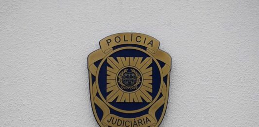 Crachá da Polícia Judiciária (PJ) numa parede