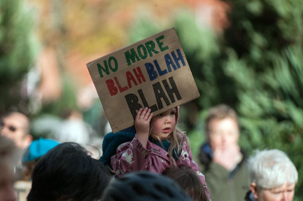 Uma criança a segurar um cartaz onde se lê "no more blah blah blah", a propósito da cimeira do clima das Nações Unidas (COP26)