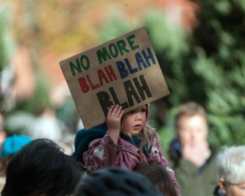 Uma criança a segurar um cartaz onde se lê "no more blah blah blah", a propósito da cimeira do clima das Nações Unidas (COP26)