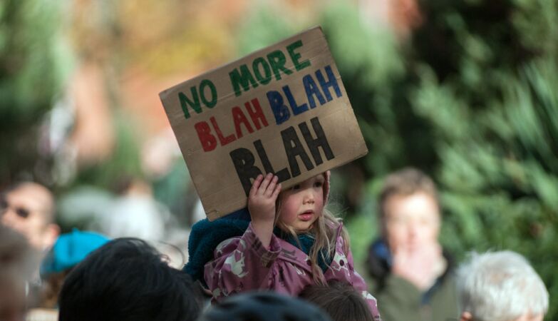 Uma criança a segurar um cartaz onde se lê "no more blah blah blah", a propósito da cimeira do clima das Nações Unidas (COP26)