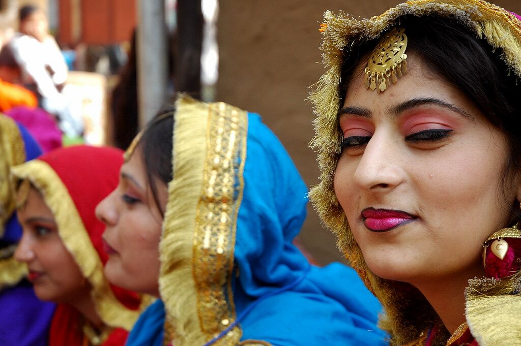 Três mulheres indianas, uma delas a sorrir