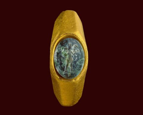 Anel de ouro com uma pedra preciosa verde e a figura do "Bom Pastor"