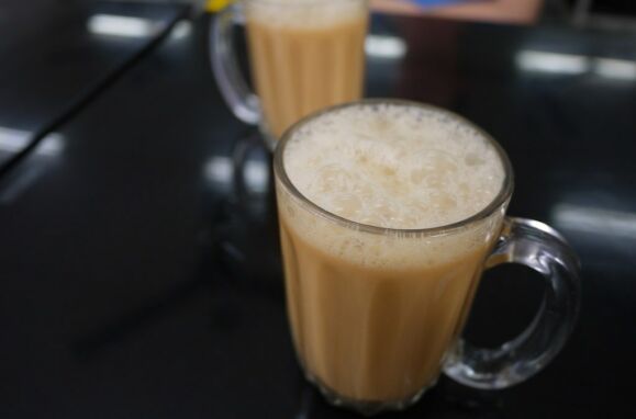 Um copo de Teh tarik – chá preto, leite condensado e muito açúcar