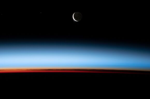 Lua crescente e o pôr-do-sol a partir da Estação Espacial Internacional