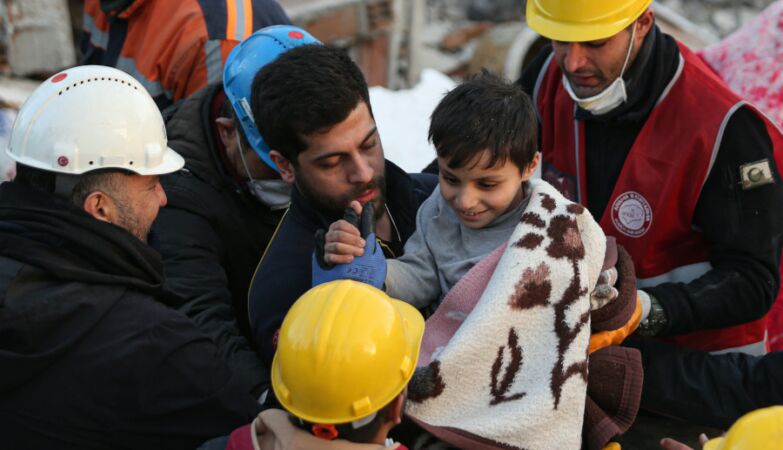 Menino a sorrir depois de ter sido resgatado após o sismo na Turquia.