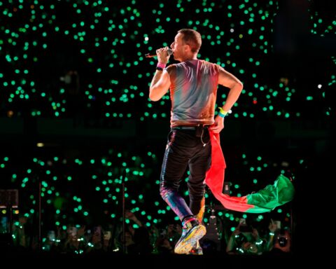 Chris Martin dos Coldplay com a bandeira portuguesa durante o concerto em Coimbra.
