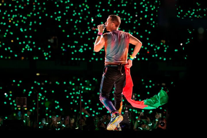 Chris Martin dos Coldplay com a bandeira portuguesa durante o concerto em Coimbra.