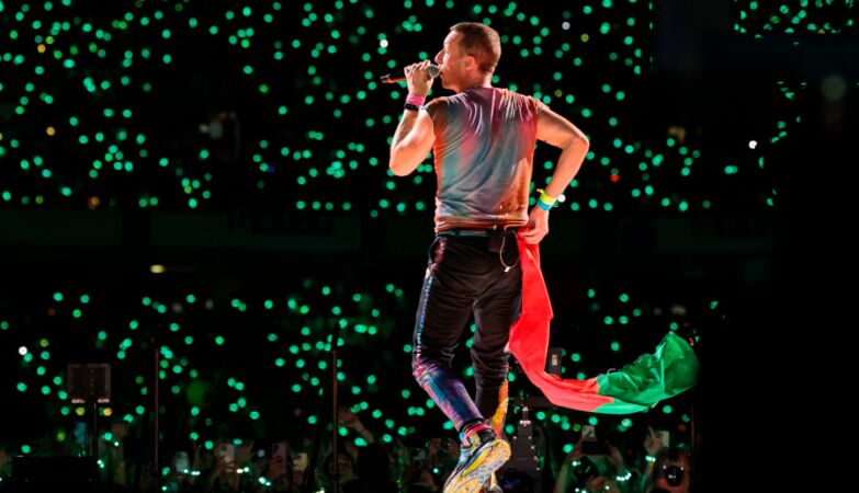 Chris Martin dos Coldplay com a bandeira portuguesa durante o concerto em Coimbra.
