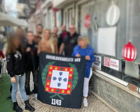 Membros do Grupo neo-nazi 1143 a segurarem bandeira que diz orgulhosamente sós.