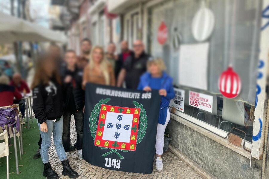 Membros do Grupo neo-nazi 1143 a segurarem bandeira que diz orgulhosamente sós.