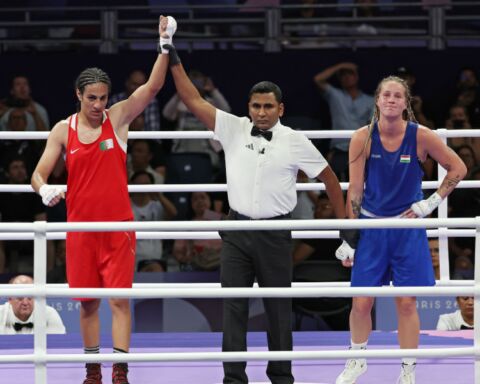 A pugilista Imane Khelif (Algéria), que veste de vermelho, é declarada vencedora no combate da categoria -66kg dos Jogos Olímpicos de Paris 2024 com a Anna Luca Hamori (Hungria) que está de azul.