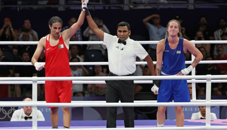 A pugilista Imane Khelif (Algéria), que veste de vermelho, é declarada vencedora no combate da categoria -66kg dos Jogos Olímpicos de Paris 2024 com a Anna Luca Hamori (Hungria) que está de azul.