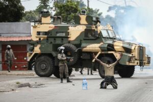 Polícia de Moçambique e manifestante durante protestos contra o resultado das eleições de Outubro de 2024.