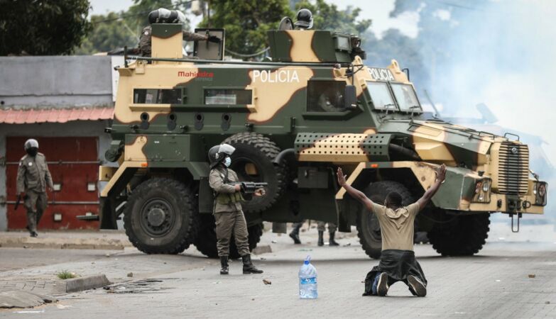 Polícia de Moçambique e manifestante durante protestos contra o resultado das eleições de Outubro de 2024.