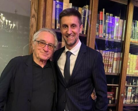 O actor Robert De Niro e o diretor de programas da SIC Daniel Oliveira lado a lado em frente a uma estante de livros.