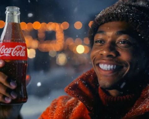 Homem moreno de gorro e sorriso aberto a segurar uma garrafa de Coca-Cola no anúncio de Natal gerado por IA.