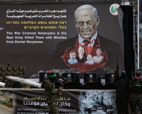 Hamas exibiu corpos dos reféns mortos em palco com uma caricatura de Netanyahu como Drácula.